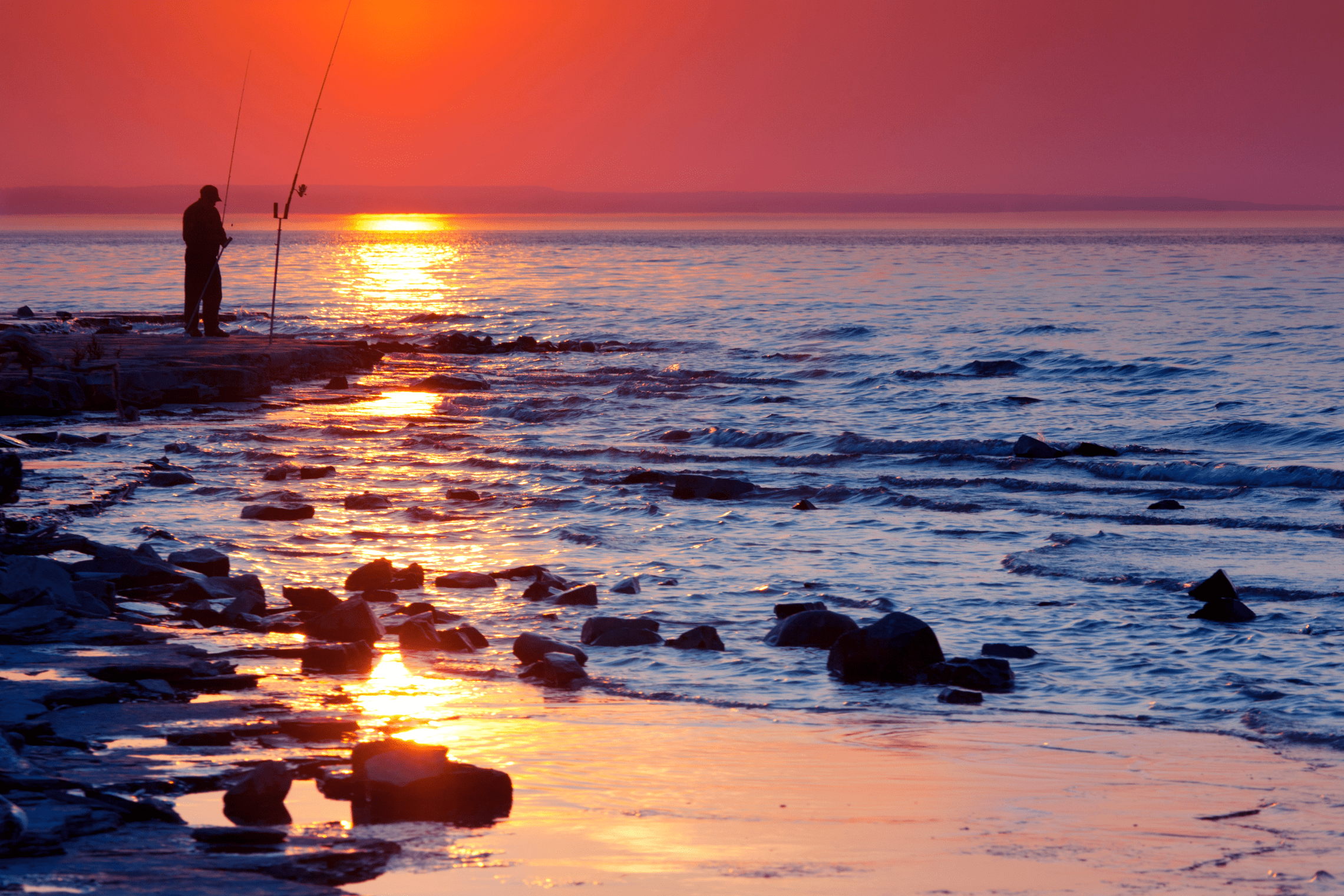 An image of a man fishing at sunset.
