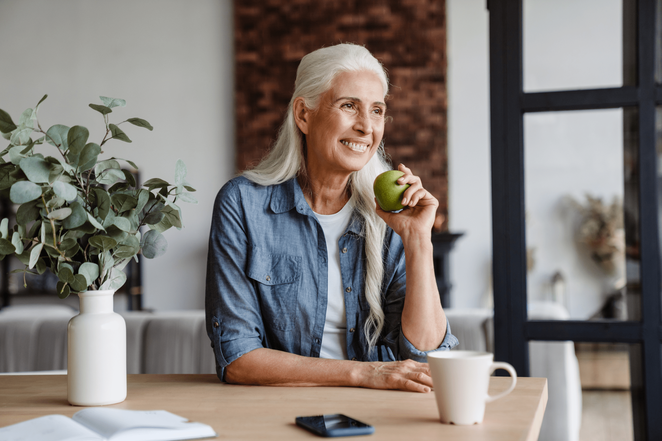 an image of a alc senior woman eating a green apple.
