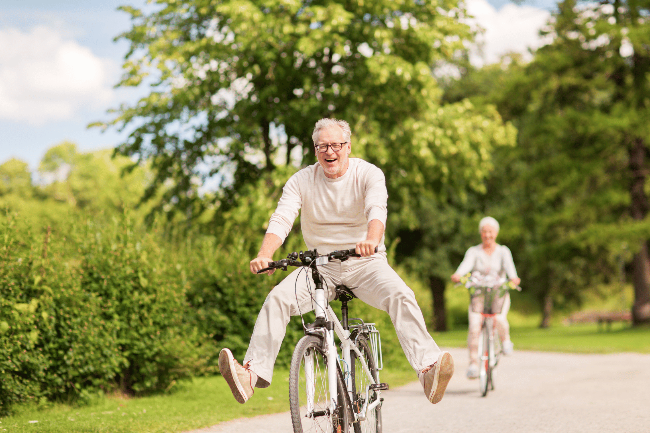 An image of an older couple bike riding together.