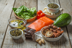 A image of salmon, avocado, nuts and other foods with healthy fats.